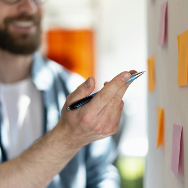 Close-up hands of a successful manager using sticky notes, agile methodology. Scrum concept