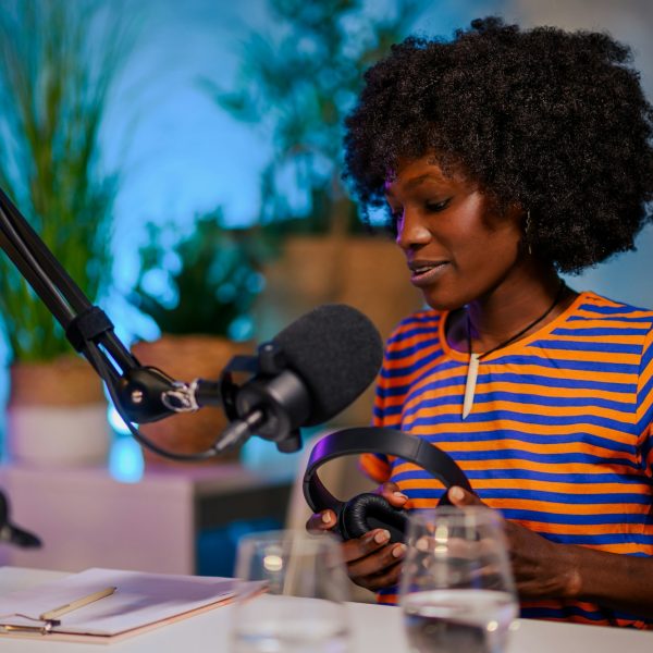 Portrait of a multicultural journalist sitting in a podcast studio